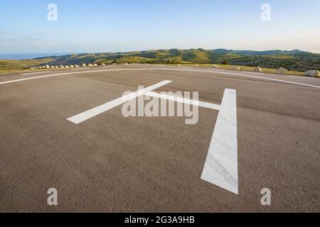 Leerer Hubschrauberlandeplatz auf einem Gipfel an einem abgelegenen Ort auf der Landseite Stockfoto