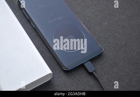 Foto eines schwarzen Smartphone mit Powerbank zum Aufladen mit schwarzem Hintergrund verbunden Stockfoto