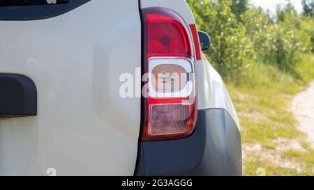 Rechter Heckscheinwerfer. Das Heck eines kleinen Beifahrerhecks oder SUV eines weißen Autos mit einer Gruppe von Schlussleuchten und einem Teil des Kofferraumdeckels auf der Rückseite Stockfoto