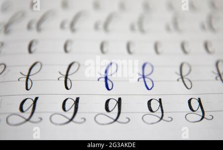 Moderne Kalligraphie Buchstaben in einem Übungsbuch Stockfoto