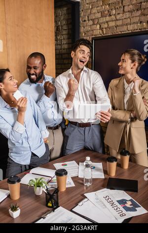 Erfolgreiche interrassische Geschäftspartner zeigen im Konferenzraum eine positive Geste Stockfoto