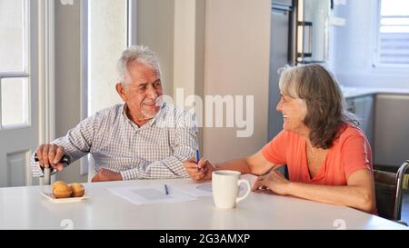 Glückliches Rentnerpaar, das zu Hause gemeinsam Gedächtnistraining gegen Demenz macht Stockfoto