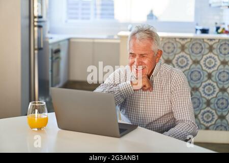 Glücklicher Senior am Laptop-Computer, der einen Videoanruf zum Geburtstag der Familie genießt Stockfoto