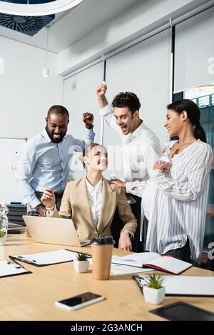 Erfolgreiche multiethnische Geschäftsleute, die während des Meetings eine positive Geste zeigten Stockfoto