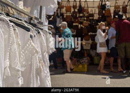 Nahaufnahme eines Wäschestuals im ibizischen Stil auf dem wöchentlichen Straßenmarkt in der mallorquinischen Stadt Campos. Aus dem Fokus, Menschen gehen mit Gesicht Mas Stockfoto