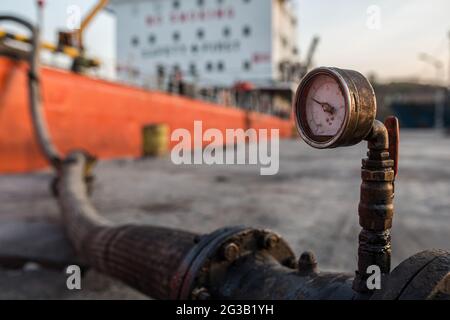 Öl wird aus dem Tanker im Hafen gepumpt. Stockfoto