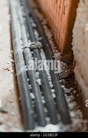 Vertikale Aufnahme von vier schwarzen Verstärkungen an der Wand Stockfoto