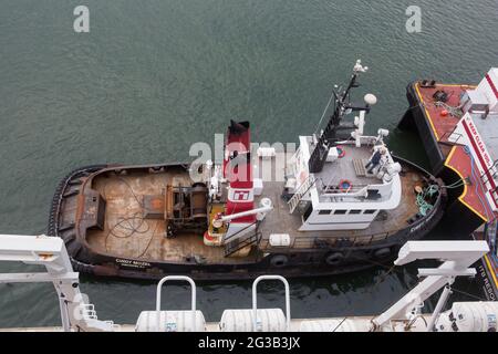 Schleppboot Cindy Mozel neben dem Carnival-Schiff im Hafen von Vancouver Stockfoto