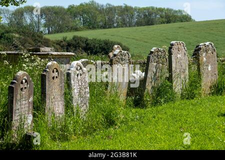 Auf dem Friedhof der St. Peter's Church in Rodmell bei Lewes in East Sussex, Großbritannien, stehen in Reihe alte Grabsteine Stockfoto