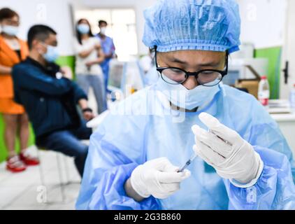 Stadt Fuyang, China. Juni 2021. Ein Mitarbeiter des Gesundheitswesens bereitet sich auf die Verabreichung einer Dosis des Sinopharm COVID-19-Impfstoffs vor. In der Impfklinik des Gesundheitszentrums der Gemeinde Gulou bereiten sich medizinische Mitarbeiter darauf vor, die Bürger mit dem inaktivierten Covid-19-Impfstoff der Sinopharm-Gruppe zu impfen. Nach Angaben der Nationalen Gesundheitsschutzkommission Chinas gaben 31 Provinzen (autonome Regionen und Gemeinden) und das Produktions- und Baukorps Xinjiang zum 14. Juni 2021 904 Millionen Dosen COVID-19-Impfstoff in 134 Tausend Dosen an. Kredit: SOPA Images Limited/Alamy Live Nachrichten Stockfoto