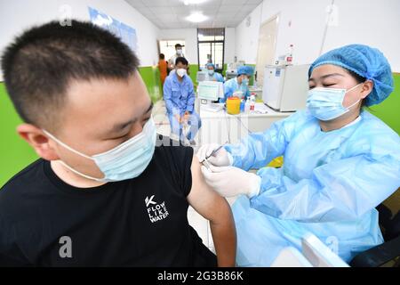 Stadt Fuyang, China. Juni 2021. Ein Gesundheitsmitarbeiter verabreicht einem Mann eine Dosis Sinopharm COVID-19-Impfstoff. In der Impfklinik des Gesundheitszentrums der Gemeinde Gulou bereiten sich medizinische Mitarbeiter darauf vor, die Bürger mit dem inaktivierten Covid-19-Impfstoff der Sinopharm-Gruppe zu impfen. Nach Angaben der Nationalen Gesundheitsschutzkommission Chinas gaben 31 Provinzen (autonome Regionen und Gemeinden) und das Produktions- und Baukorps Xinjiang zum 14. Juni 2021 904 Millionen Dosen COVID-19-Impfstoff in 134 Tausend Dosen an. Kredit: SOPA Images Limited/Alamy Live Nachrichten Stockfoto