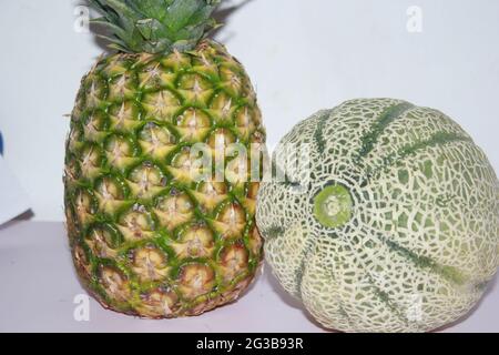 Ananas und Melone auf weißem Hintergrundbild. Stockfoto