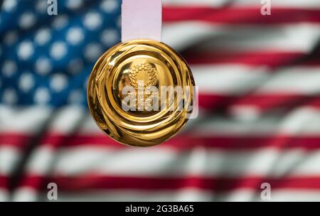 25. April 2021 Tokio, Japan. Goldmedaille der XXXII. Olympischen Sommerspiele 2020 in Tokio auf dem Hintergrund der US-Flagge. Stockfoto