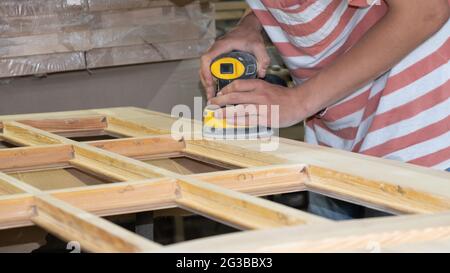 Restaurationstür, Polieren mit einer Schleifmaschine. Stockfoto