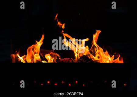 Brennendes Holzfeuer In Brazier Auf Schwarzem Dunklen Hintergrund Im Freien. Stockfoto