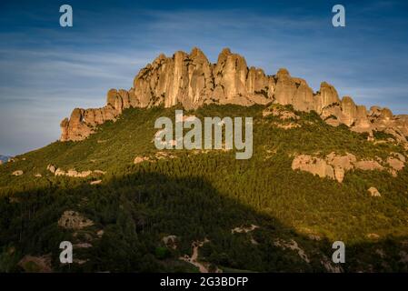 Montserrat Westwand mit einigen Felsformationen wie Roca Foradada und Serrat de la Portella, bei Sonnenuntergang, von Castellferran aus gesehen (Barcelona, Katalonien) Stockfoto