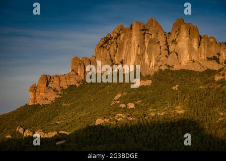 Montserrat Westwand mit einigen Felsformationen wie Roca Foradada und Serrat de la Portella, bei Sonnenuntergang, von Castellferran aus gesehen (Barcelona, Katalonien) Stockfoto