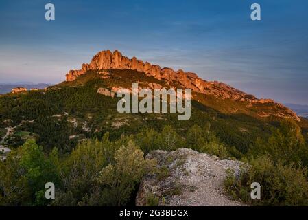 Montserrat Westwand mit einigen Felsformationen wie Roca Foradada und Serrat de la Portella, bei Sonnenuntergang, von Castellferran aus gesehen (Barcelona, Katalonien) Stockfoto