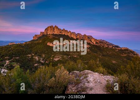 Montserrat Westwand mit einigen Felsformationen wie Roca Foradada und Serrat de la Portella, bei Sonnenuntergang, von Castellferran aus gesehen (Barcelona, Katalonien) Stockfoto