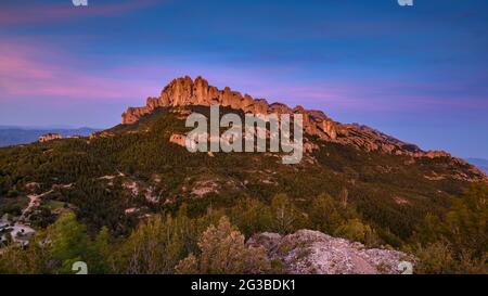 Montserrat Westwand mit einigen Felsformationen wie Roca Foradada und Serrat de la Portella, bei Sonnenuntergang, von Castellferran aus gesehen (Barcelona, Katalonien) Stockfoto