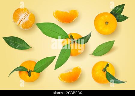 Mandarine- oder Mandarinenfrucht mit isolierten Blättern auf gelbem Hintergrund. Stockfoto