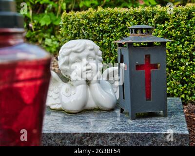 Ein verträumter Engel und eine christliche Laterne auf einem Marmorblock Stockfoto