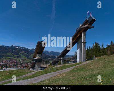 Blick auf die Skisprungschanze Audi Arena, Teil des berühmten Vierschanzenturniers, an einem sonnigen Tag im Frühsommer mit den Allgäuer Bergen. Stockfoto