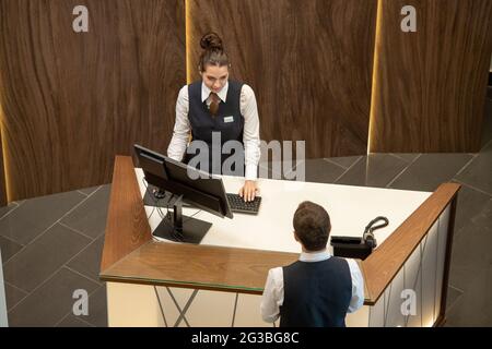 Junge Hotelmanager kommunizieren über den Schalter in der Lounge Stockfoto