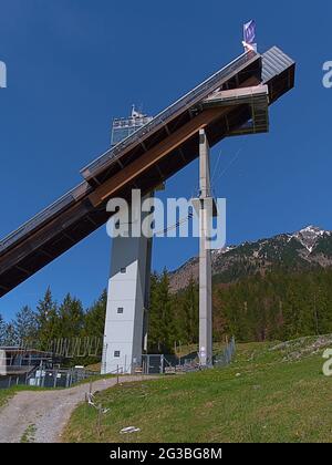 Blick auf den oberen Teil der Skisprungschanze Audi Arena, Teil des berühmten Vierschanzenturniers, an einem sonnigen Tag im Frühsommer mit dem Allgäu Stockfoto