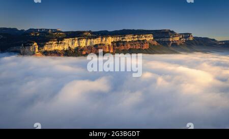 Sonnenaufgang mit einem Meer von Wolken über dem Stausee von Sau, mit Blick auf die Klippen von Tavertet. Von der Roca del Migdia, Osona, Barcelona, Katalonien, Spanien aus gesehen Stockfoto