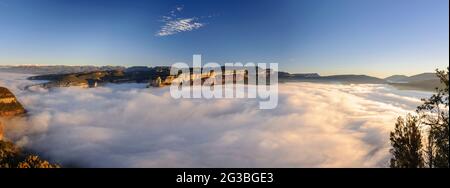 Sonnenaufgang mit einem Meer von Wolken über dem Stausee von Sau, mit Blick auf die Klippen von Tavertet. Von der Roca del Migdia, Osona, Barcelona, Katalonien, Spanien aus gesehen Stockfoto