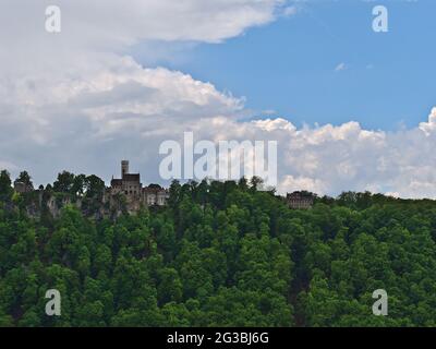 Schöne Aussicht auf das berühmte Schloss Lichtenstein (erbaut 1842), das sich am Albtrauf der Schwäbischen Alb, Deutschland, inmitten eines grünen Waldes, befindet. Stockfoto