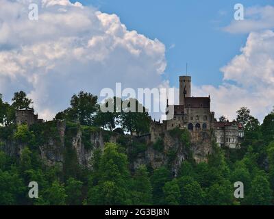 Blick auf das berühmte Schloss Lichtenstein (19. Jahrhundert, gotischer Revival-Stil) am Rande ('Albtrauf') der Schwäbischen Alb, Deutschland mit steilen Felsen. Stockfoto