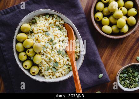 Bulgur mit grünen Oliven und Pepitas, gesunde Ernährung einfach Rezept aus lange gelagerten Lebensmitteln. Stockfoto