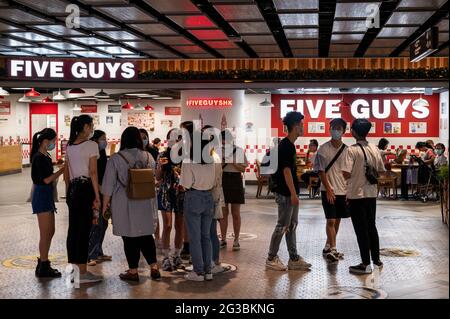 Hongkong, China. Juni 2021. Menschen werden vor der amerikanischen Fast-Casual-Restaurantkette Five Guys in Hongkong gesehen. (Foto von Budrul Chukrut/SOPA Images/Sipa USA) Quelle: SIPA USA/Alamy Live News Stockfoto
