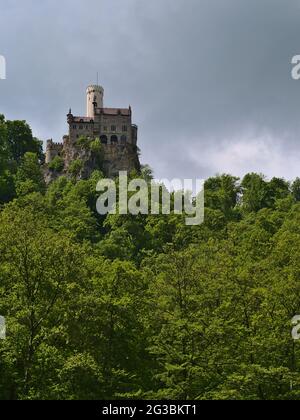 Niederwinkliger Blick auf Schloss Lichtenstein am Rande der Schwäbischen Alb, Baden-Württemberg, Deutschland, umgeben von grünem Wald. Stockfoto