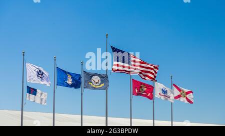 Flagge der Vereinigten Staaten, Florida Staatsflagge, christliche Flagge und Militärs Flaggen fliegen an sonnigen Tagen mit blauem Himmel. Stockfoto