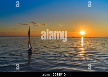 Riga, Lettland 12-06-2021 Segelyacht gegen Sonnenuntergang. Urlaub Lifestyle Landschaft mit Skyline Segelboot. Yachting Tourismus - maritimer Abendspaziergang. Rom Stockfoto