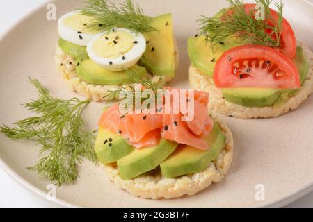 Reisbrot knusprig gezüchtet, Avocado, gekochte Eier Scheiben, Lachs, Tomaten und frischen Dill Stockfoto