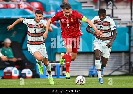 15. Juni 2021, Ungarn, Budapest: Fußball: Europameisterschaft, Ungarn - Portugal, Vorrunde, Gruppe F, Matchday 1 in der Puskás Arena. Der ungarische Adam Szalai (m), der portugiesische Ruben Dias (l) und der portugiesische William Carvalho kämpfen um den Ball. Wichtig: Nur für redaktionelle Zwecke. Ohne vorherige schriftliche Genehmigung der UEFA nicht für kommerzielle oder Marketingzwecke verwendet. Bilder müssen als Standbilder erscheinen und dürfen keine Matchaction-Videoaufnahmen emulieren. Quelle: dpa picture Alliance/Alamy Live News Stockfoto