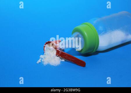 Sichtbar ist das Milchpulver, das zusammen mit einem Sauger aus dem Löffel verschüttet wurde Stockfoto
