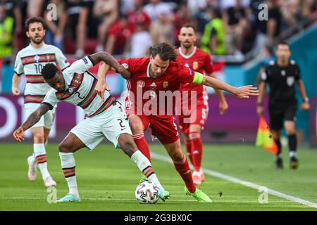 15. Juni 2021, Ungarn, Budapest: Fußball: Europameisterschaft, Ungarn - Portugal, Vorrunde, Gruppe F, Matchday 1 in der Puskás Arena. Der portugiesische Nelson Semedo (l.) und der ungarische Adam Szalai kämpfen um den Ball. Wichtig: Nur für redaktionelle Zwecke. Ohne vorherige schriftliche Genehmigung der UEFA nicht für kommerzielle oder Marketingzwecke verwendet. Bilder müssen als Standbilder erscheinen und dürfen keine Matchaction-Videoaufnahmen emulieren. Fotos, die in Online-Publikationen veröffentlicht werden (ob über das Internet oder anderweitig), müssen zwischen der Veröffentlichung mindestens 20 Sekunden lang liegen. Quelle: dpa picture allia Stockfoto