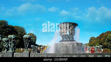 Der Panoramablick auf den malerischen Bronzebrunnen The Burden of Life von Gustav Vigeland, umgeben von bronzenen Skulpturengruppen mit einem Regenbogen i Stockfoto