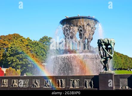 Genießen Sie den farbenfrohen doppelten Regenbogen vor dem bronzenen Vigeland-Brunnen im Frogner Park, Oslo, Norwegen Stockfoto