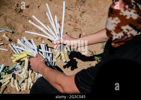 Gaza, Palästina. Juni 2021. Maskierte Palästinenser bereiten Brandballons vor, um vom Gazastreifen aus in Richtung Israel zu starten. Palästinensische Aktivisten starten brennende Ballons aus dem Gazastreifen in Richtung Israel, um gegen den derzeit stattfindenden flaggenmarsch in Ostjerusalem zu protestieren und um einen erneuten Ausbruch von Gewalt zu sorgen, da etwa 5,000 rechte Nationalisten mit der blau-weißen Flagge Israels durch die Jerusalemer Altstadt ziehen werden. Gaza-Brandballons verbrannten Ackerland an mindestens 13 verschiedenen Orten, berichtet israelische Medien. Kredit: SOPA Images Limited/Alamy Live Nachrichten Stockfoto