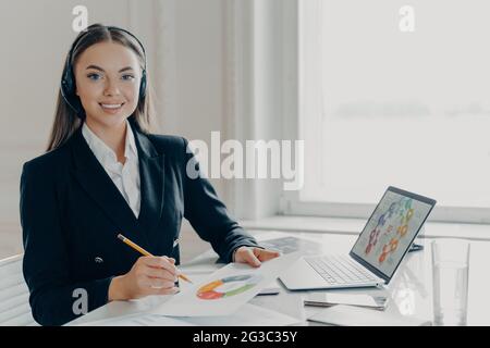 Professionelle Geschäftsfrau im Headset, die sich auf die Online-Präsentation vorbereitet Stockfoto