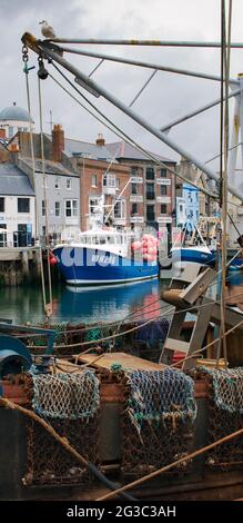 Weymouth, UK - 23. Mai 2021: Fischerboote auf einem Kanal in Weymouth geparkt Stockfoto