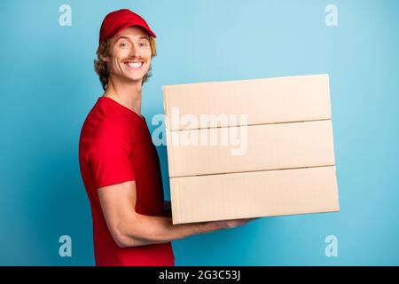 Profil Porträt von schönen Kerl Hände halten Boxen tragen Hut isoliert auf pastellblauen Hintergrund Stockfoto