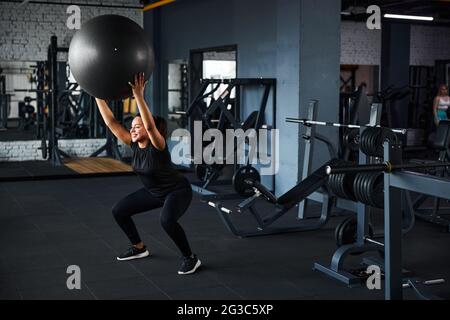 Fröhliche weibliche tun Ganzkörpertraining im Fitnessstudio Stockfoto