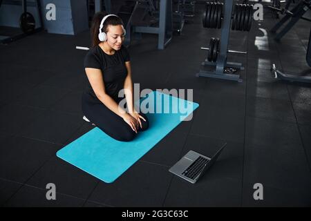 Glückliche Frau beim Online-Training im Fitnessstudio Stockfoto